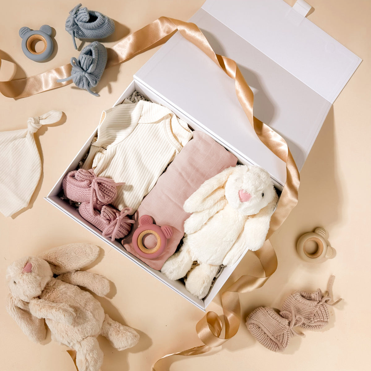 newborn-baby-gifts-for-girls-with-cotton-onesie-and-beanie-and-pink-booties-and-muslin-wrap